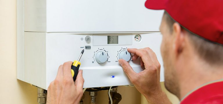 man in read installs tankless gas water heater