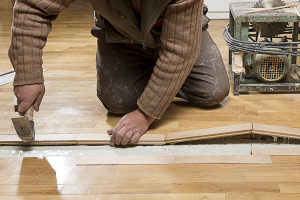Plumber repairing flooring after slab leak signs