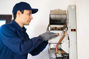 Plumber examining whether to repair a water heater
